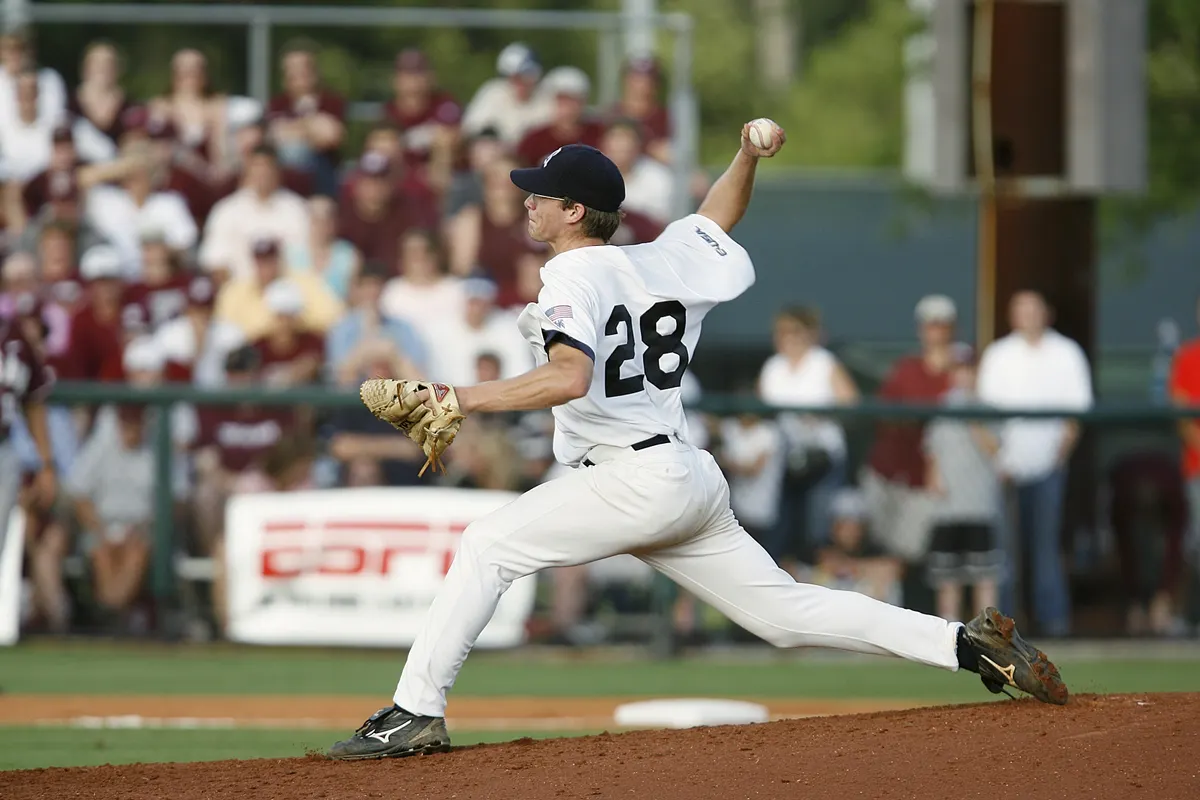 Baseball pitcher delivering a pitch from the mound.
