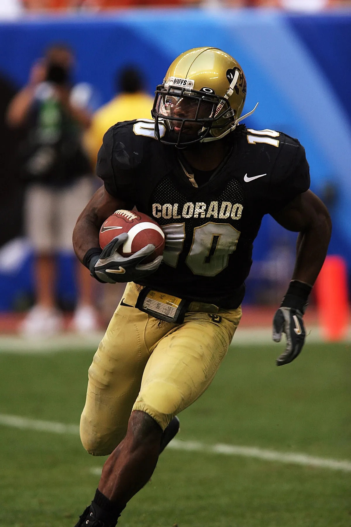 American football player carrying the ball during a game.