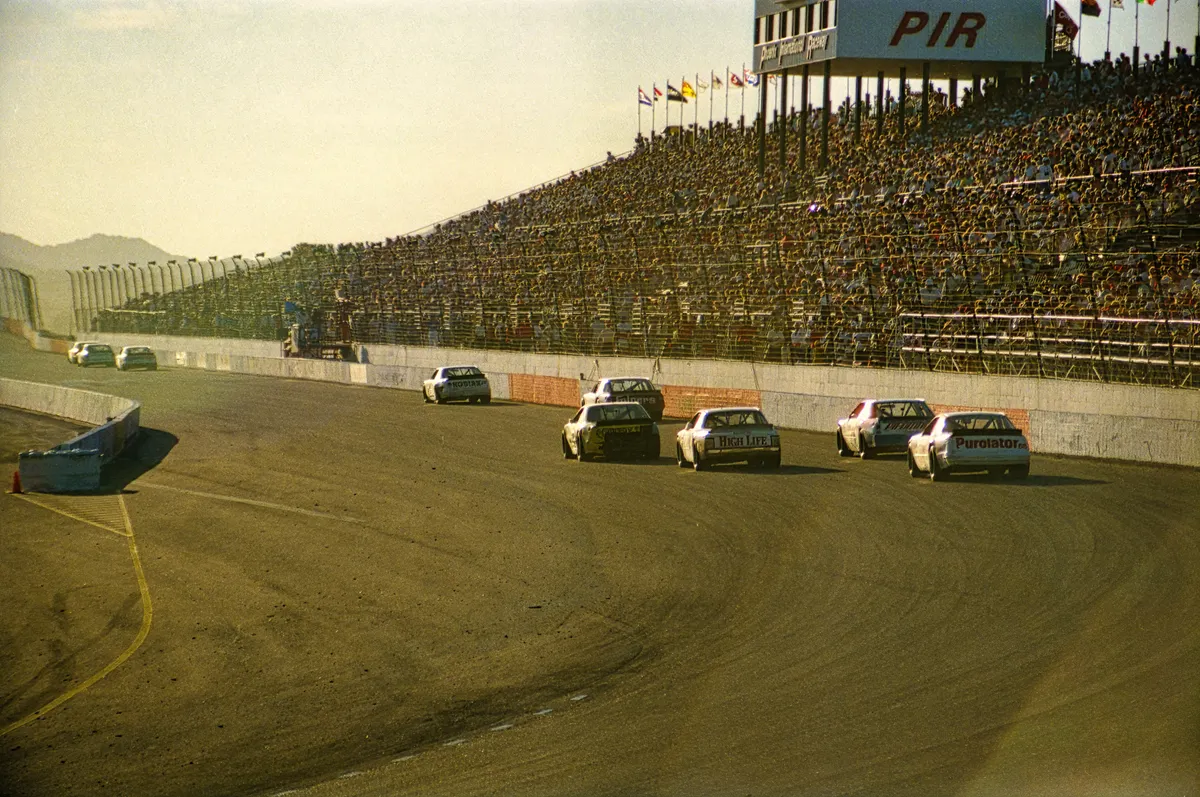 Stock cars racing past the grandstands at Phoenix International Raceway.